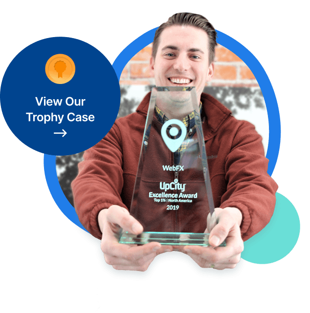 A smiling person holding a clear glass trophy with the text 'Magnix UpCity Excellence Award Top 1% North America 2019'.